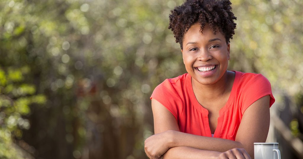 woman smiling in orange shirt