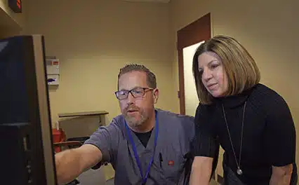 radiologist looking at scan in scrubs