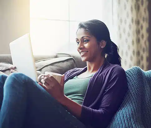 woman holding coffee on her ipad